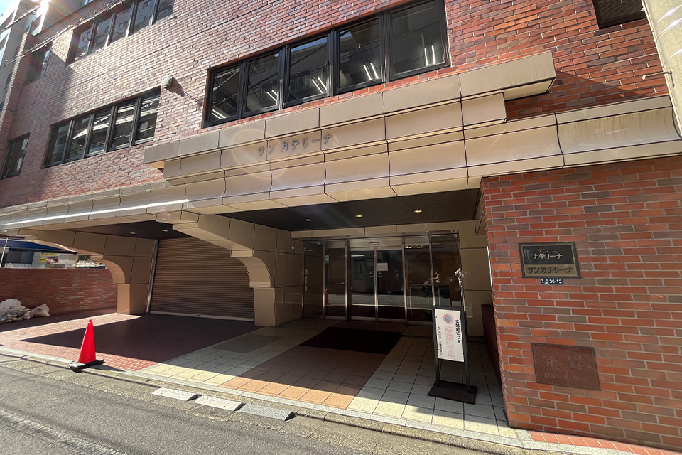 株式会社ディライトの新宿本社入口が写されたサンカテリーナビル正面で葬儀相談の案内看板が出ている風景